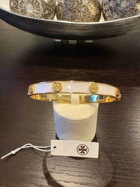 SOLD


Tory Burch Gold-Tone Bangle with White Enamel and Logo Medallions